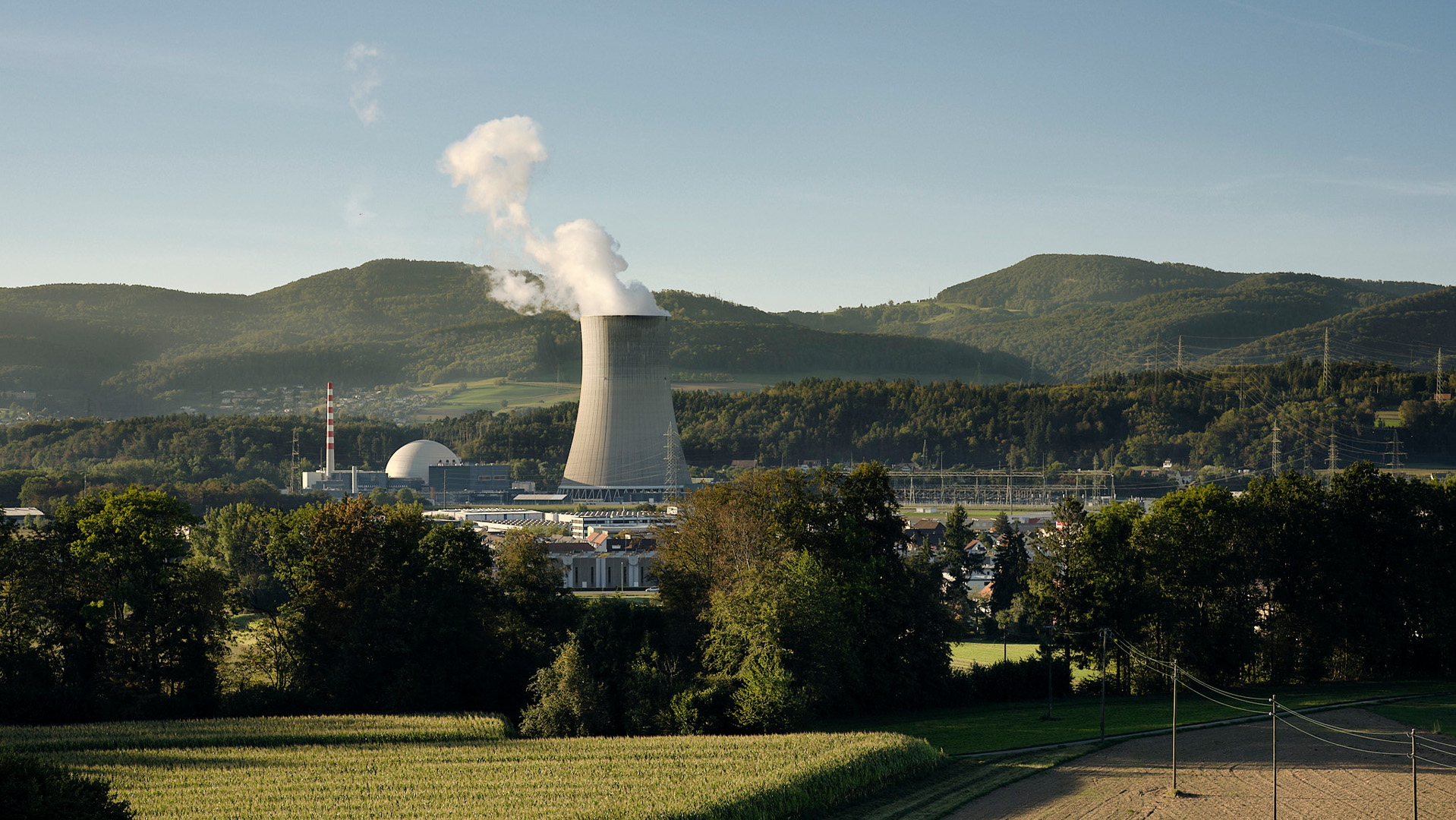 Blick auf ein Kernkraftwerk mit Hügeln im Hintergrund
